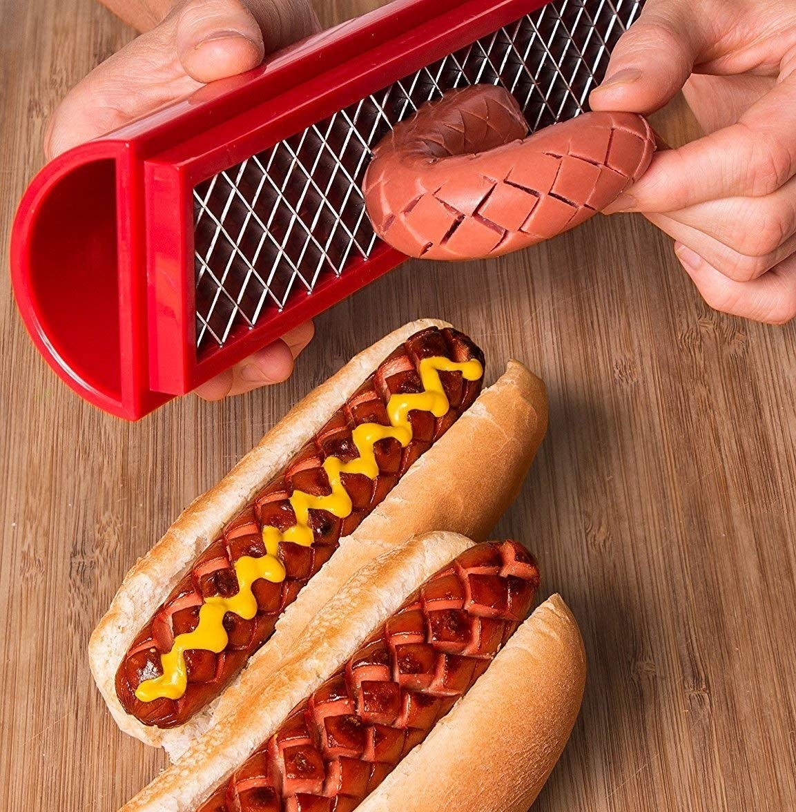 A person using the slicer on a hot dog
