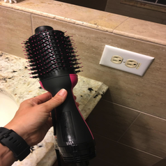 reviewer holding the black and pink hot air brush