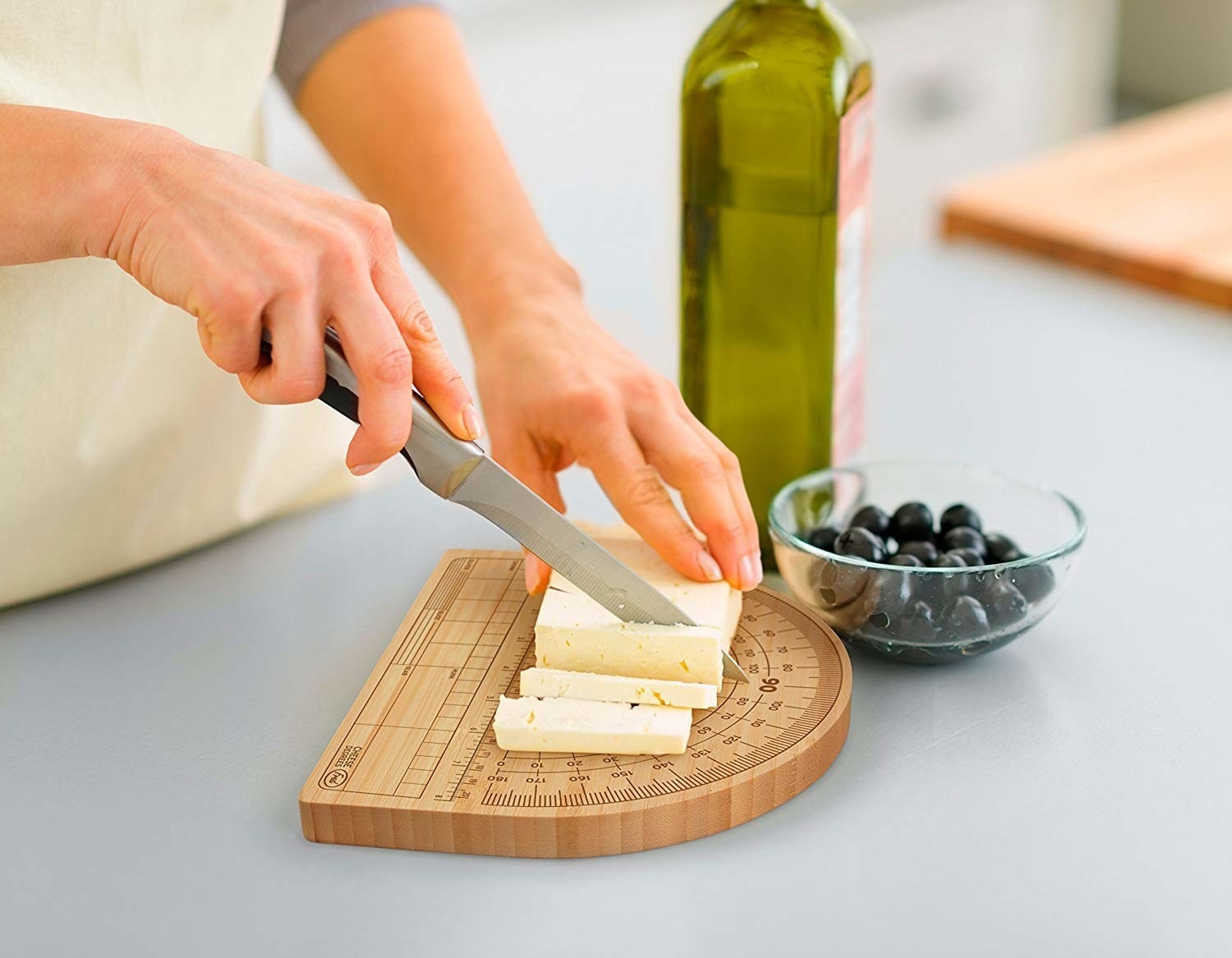 A person using the board to cut cheese