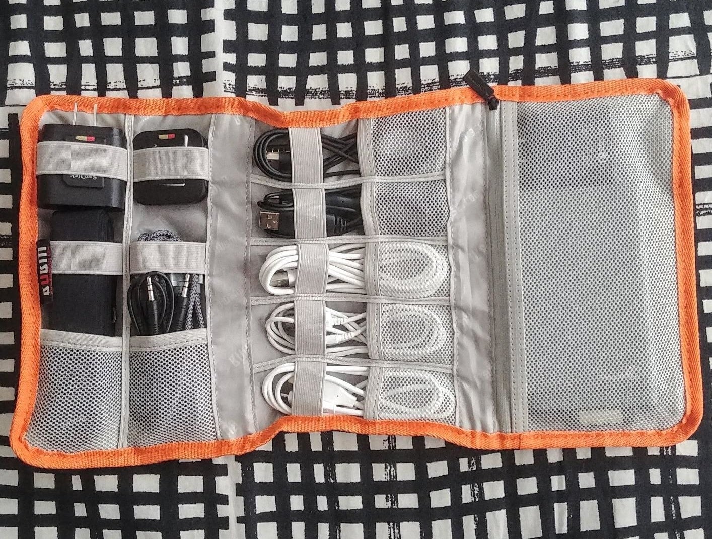 reviewer&#x27;s organizer with different rolled up cords and plugs inside of the compartments 