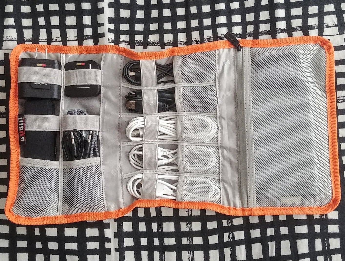 reviewer&#x27;s organizer with different rolled up cords and plugs inside of the compartments 