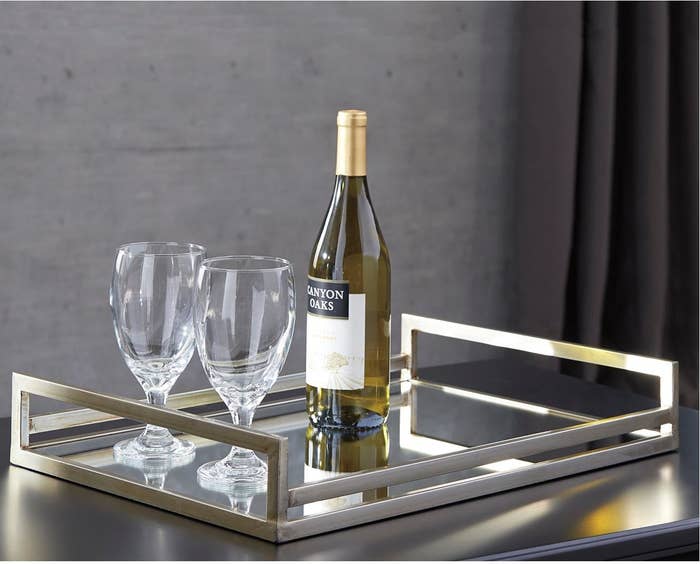 the silver tray with a bottle of wine and two wine glasses