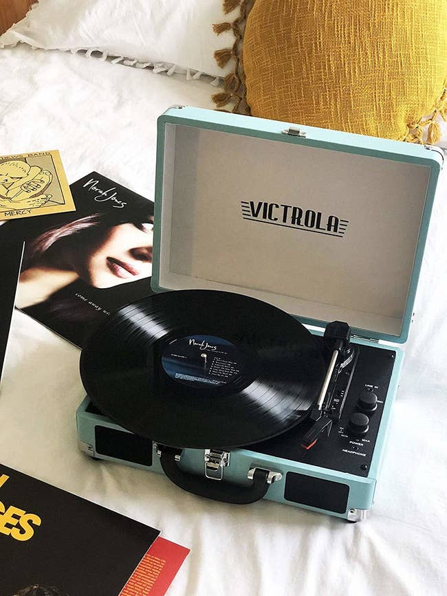 A light blue record player with a norah jones record on it 