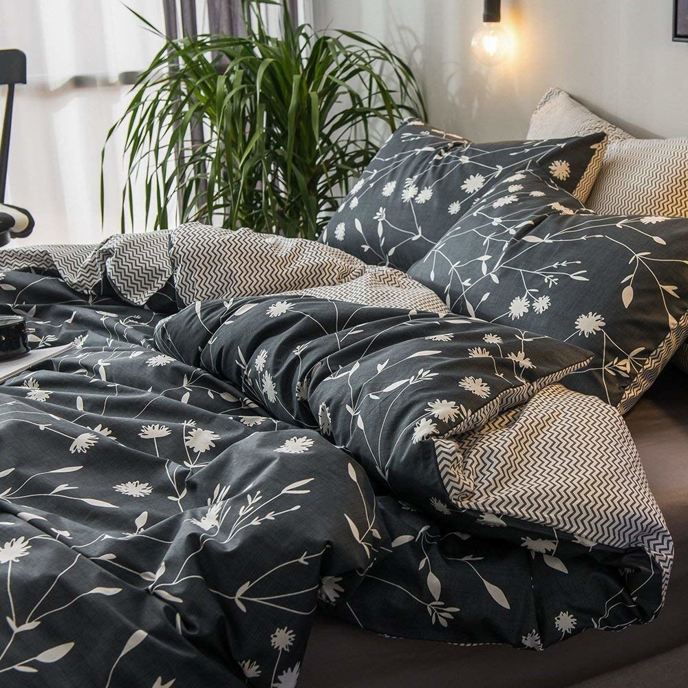 the reversible duvet set that is dark grey with a white floral print on one side with grey and white squiggly stripes on the other