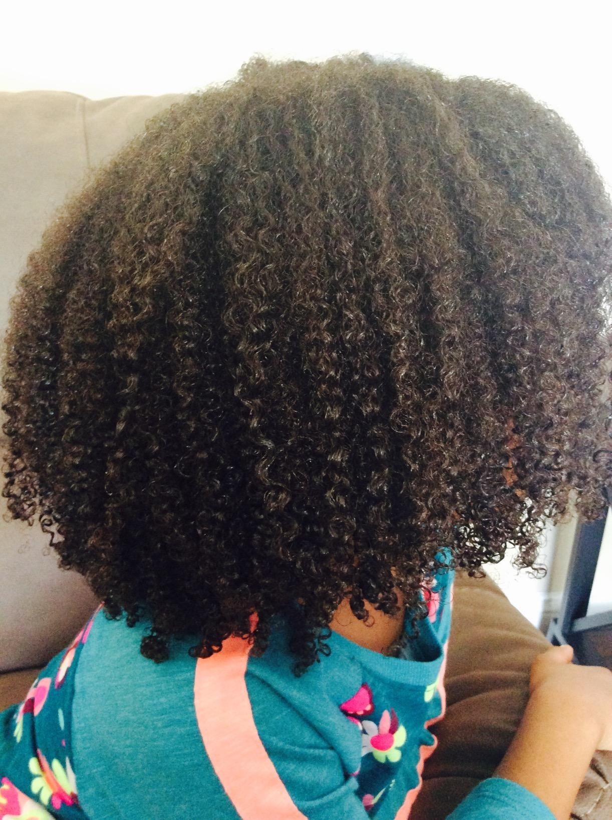 Reviewer with natural hair who used the conditioner to get curl definition and shine