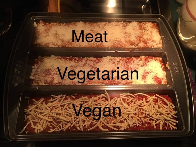 Baking pan with three sections — one with meat lasagna, one with vegetarian lasagna, and one with vegan lasagna