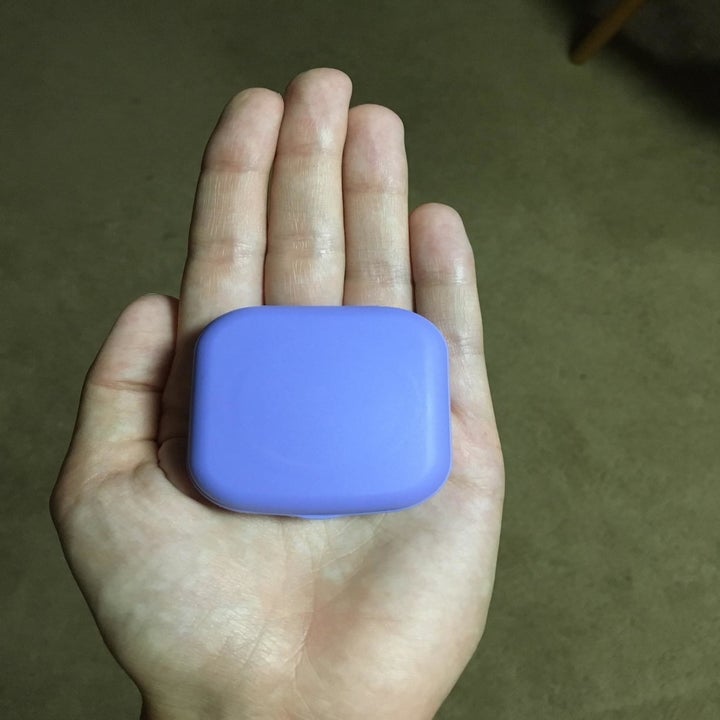 Reviewer holding square shaped lens holder in their palm 