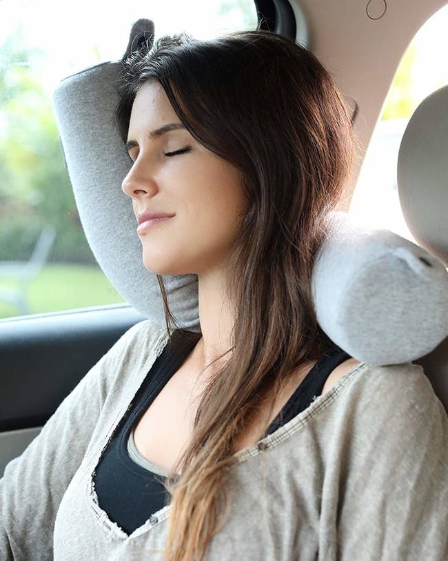 model sleeping against car door thanks to bending travel pillow