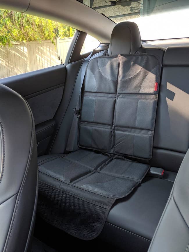 reviewer photo of the black car seat protector in the backseat