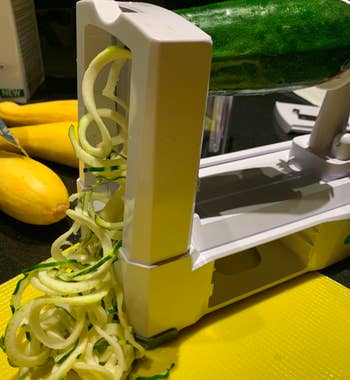 reviewer photo of zucchini being spiraled out of the spiralizer