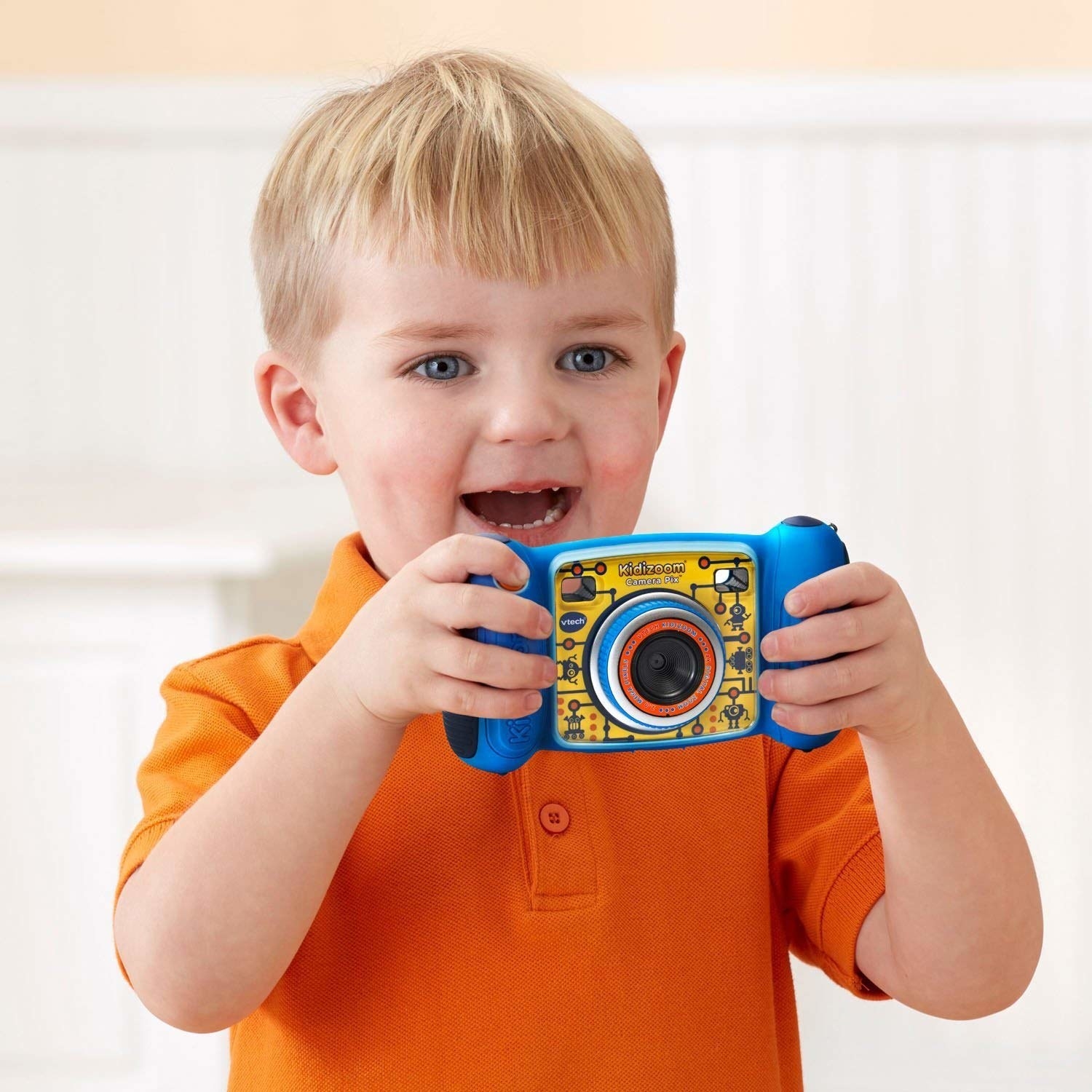 A child holding up a small camera