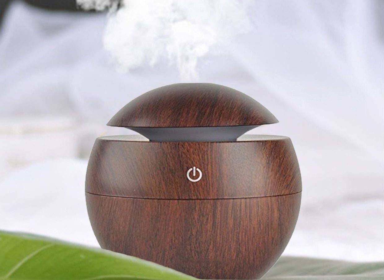 A brown diffuser on a table, releasing essential oils in the air 