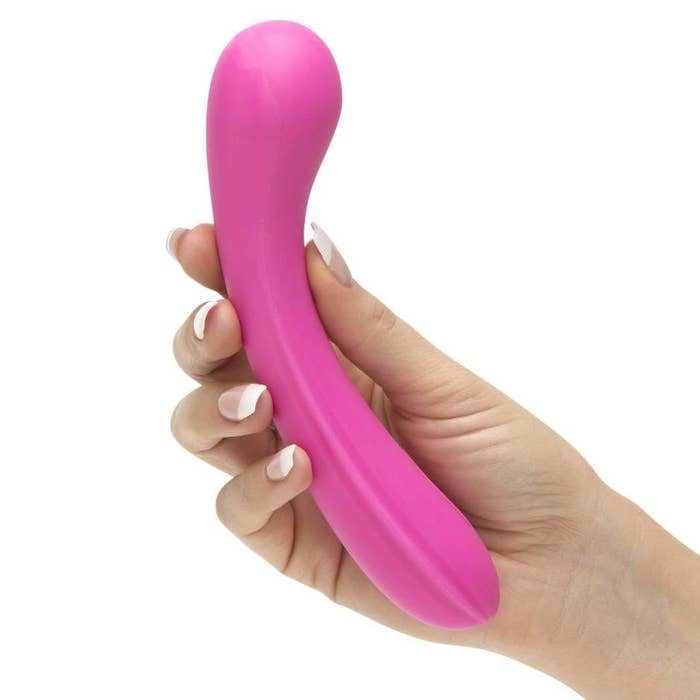 a hand holding the slightly-curved dildo 