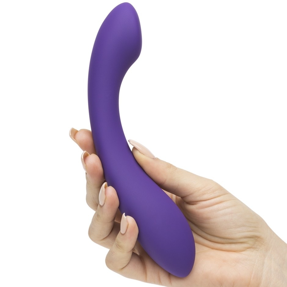 a hand holding the smooth purple dildo