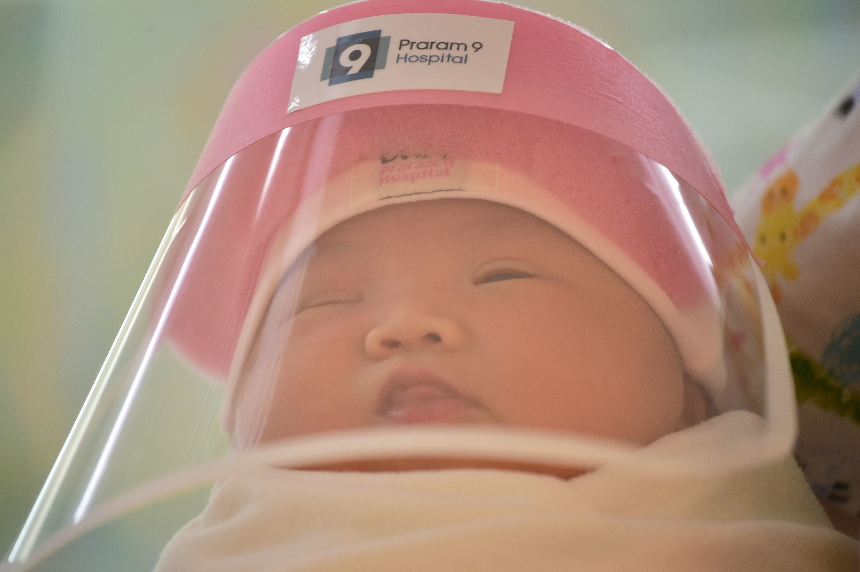 Newborn baby wears a face shield in Bangkok hospital