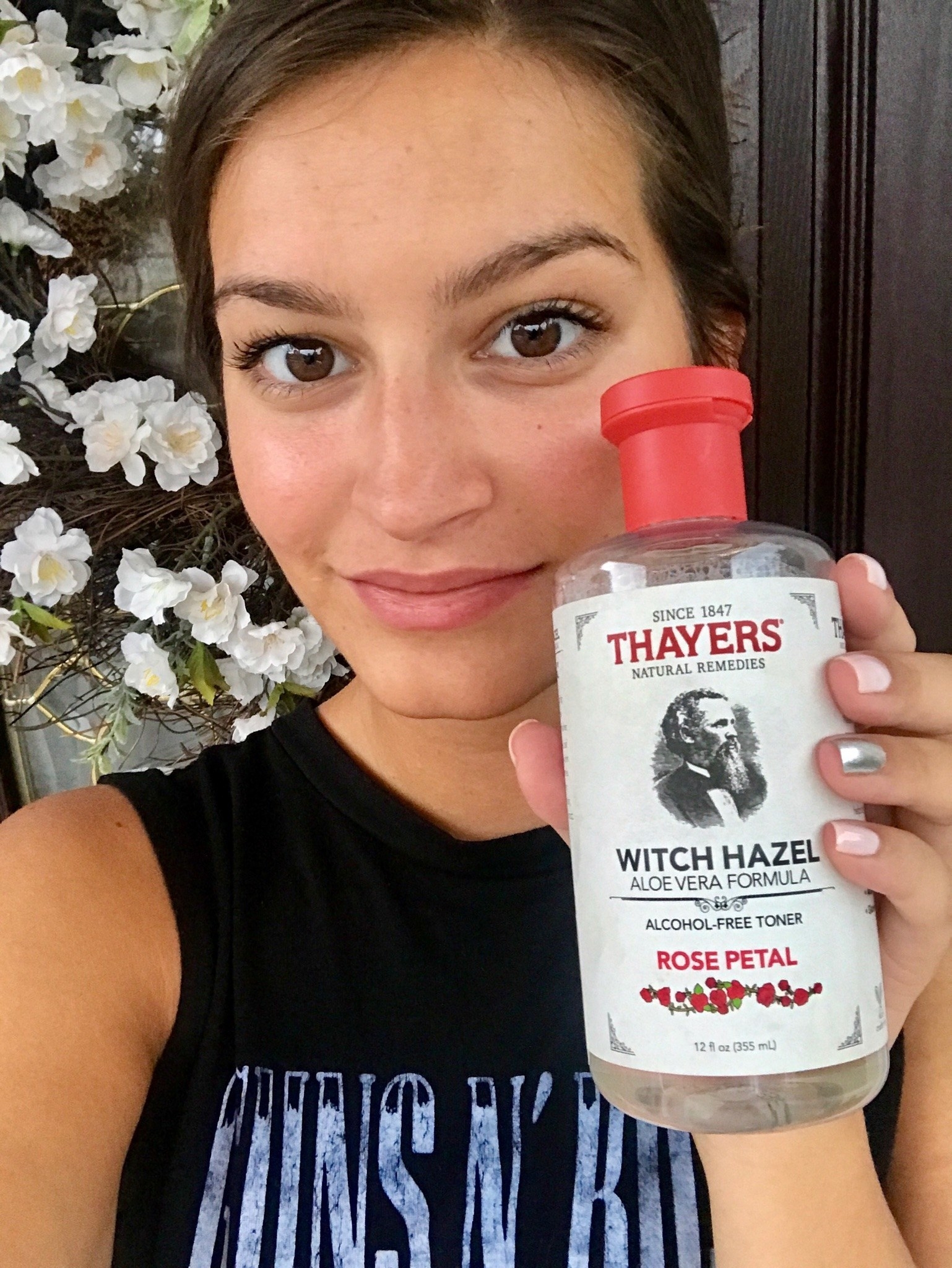 BuzzFeed Editor holding up the witch hazel toner with red cap
