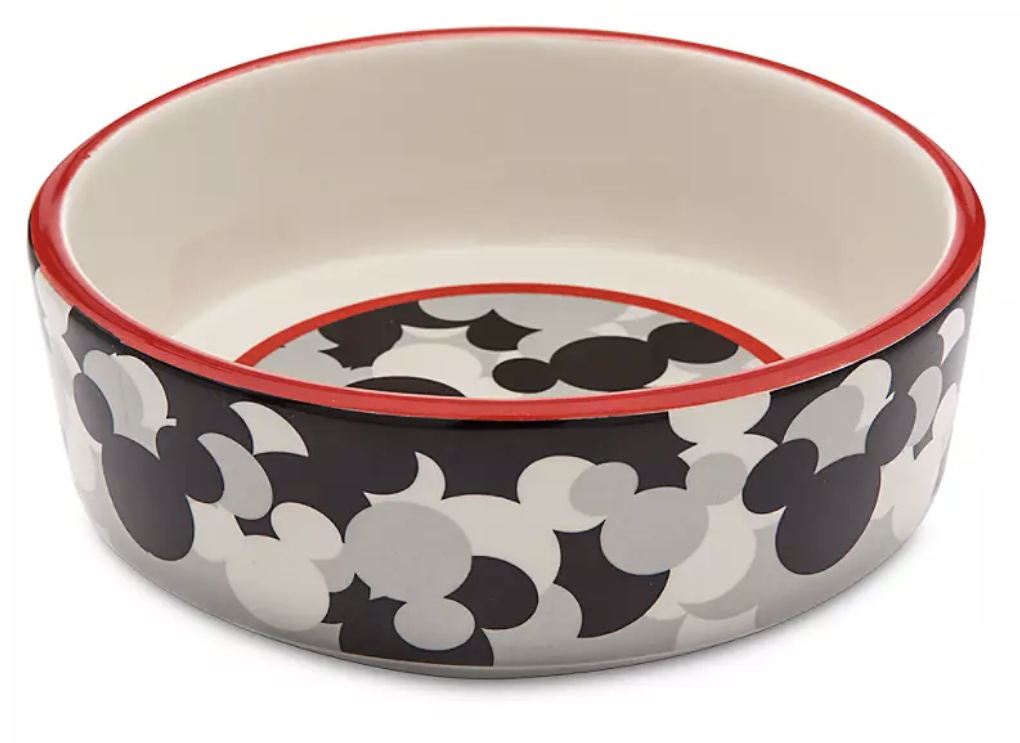 a round ceramic dog bowl with a black white and grey mickey design on it and a red accent around the edge