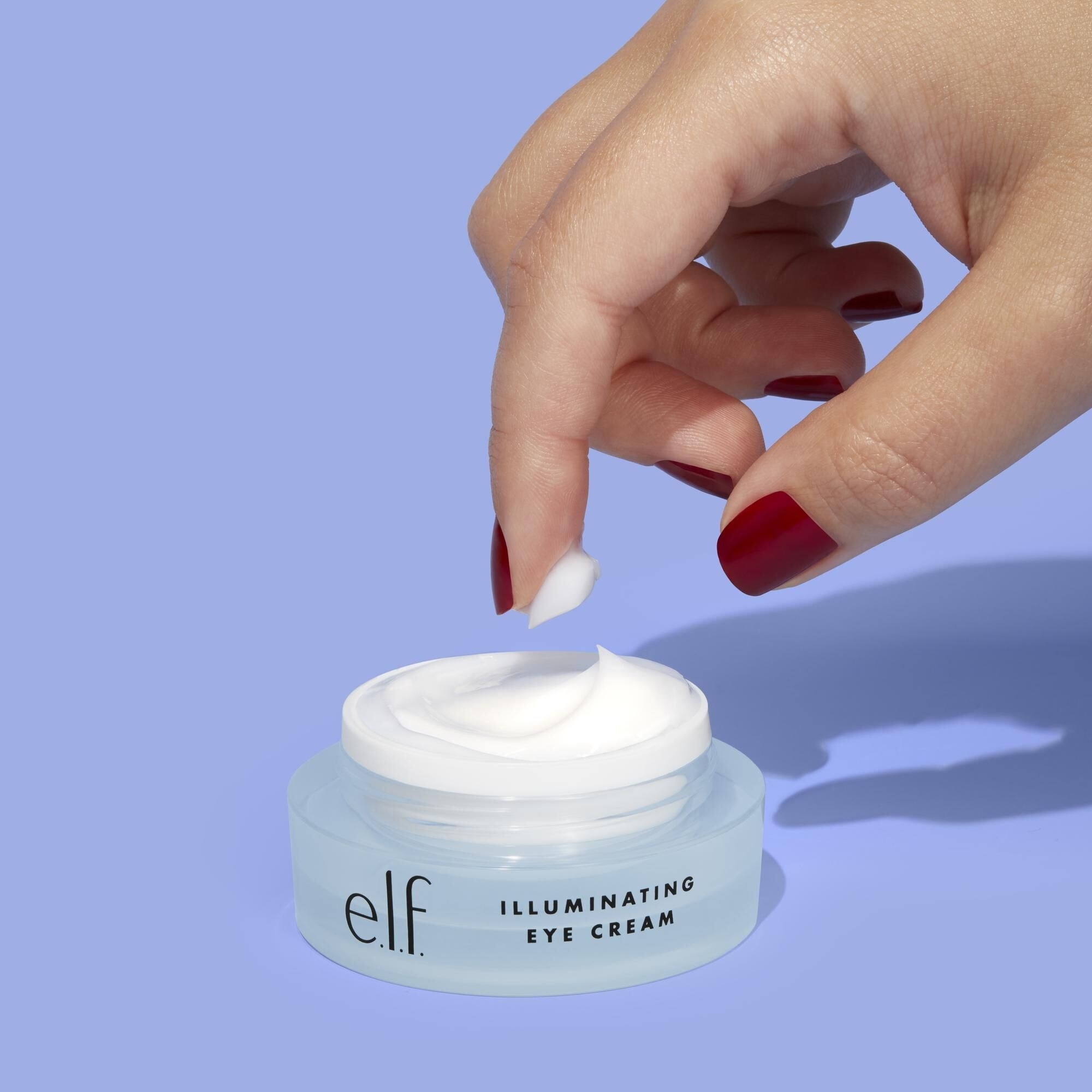 Finger dipping into the jar of eye cream