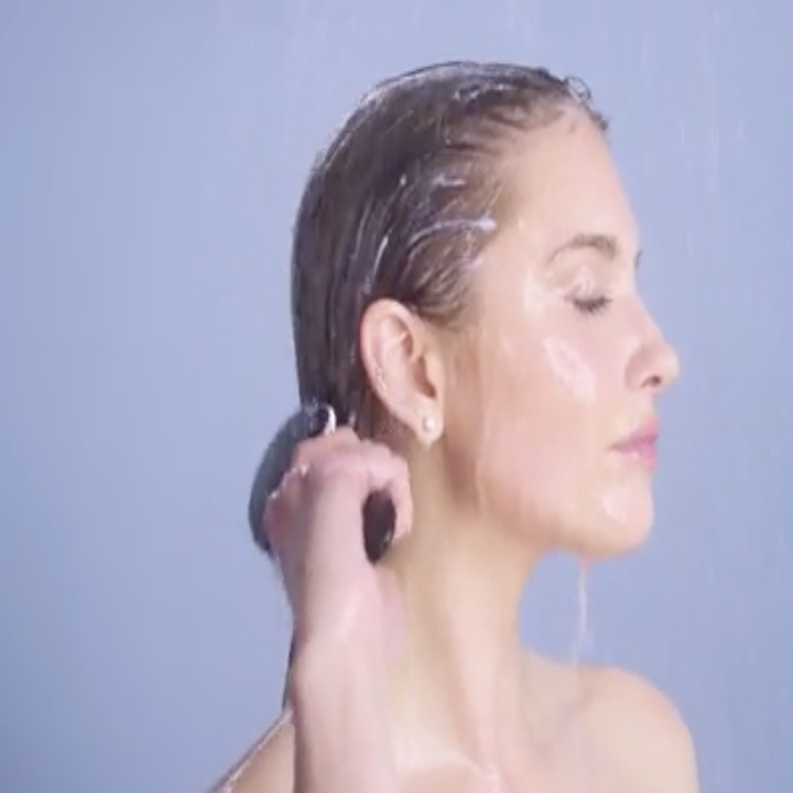 model combs same mask through hair in shower