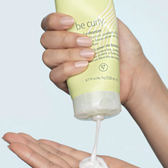 hand squeezes tube of the same curl enhancer
