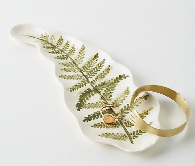 white dish painted with a fern leaf