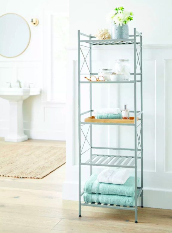 Five-tier decorative shelf in metal with bathroom towels and plants 