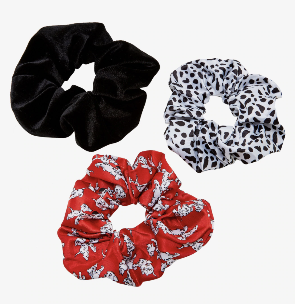 three scrunchies: one is black, one is white with black spots, one is red with Dalmatian puppies on it