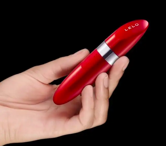 Oval red tube that looks like lipstick held in model&#x27;s fingers 