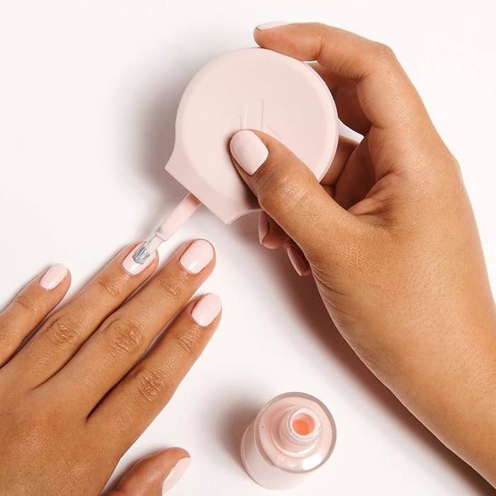 Model holding the circular grip while painting their nails