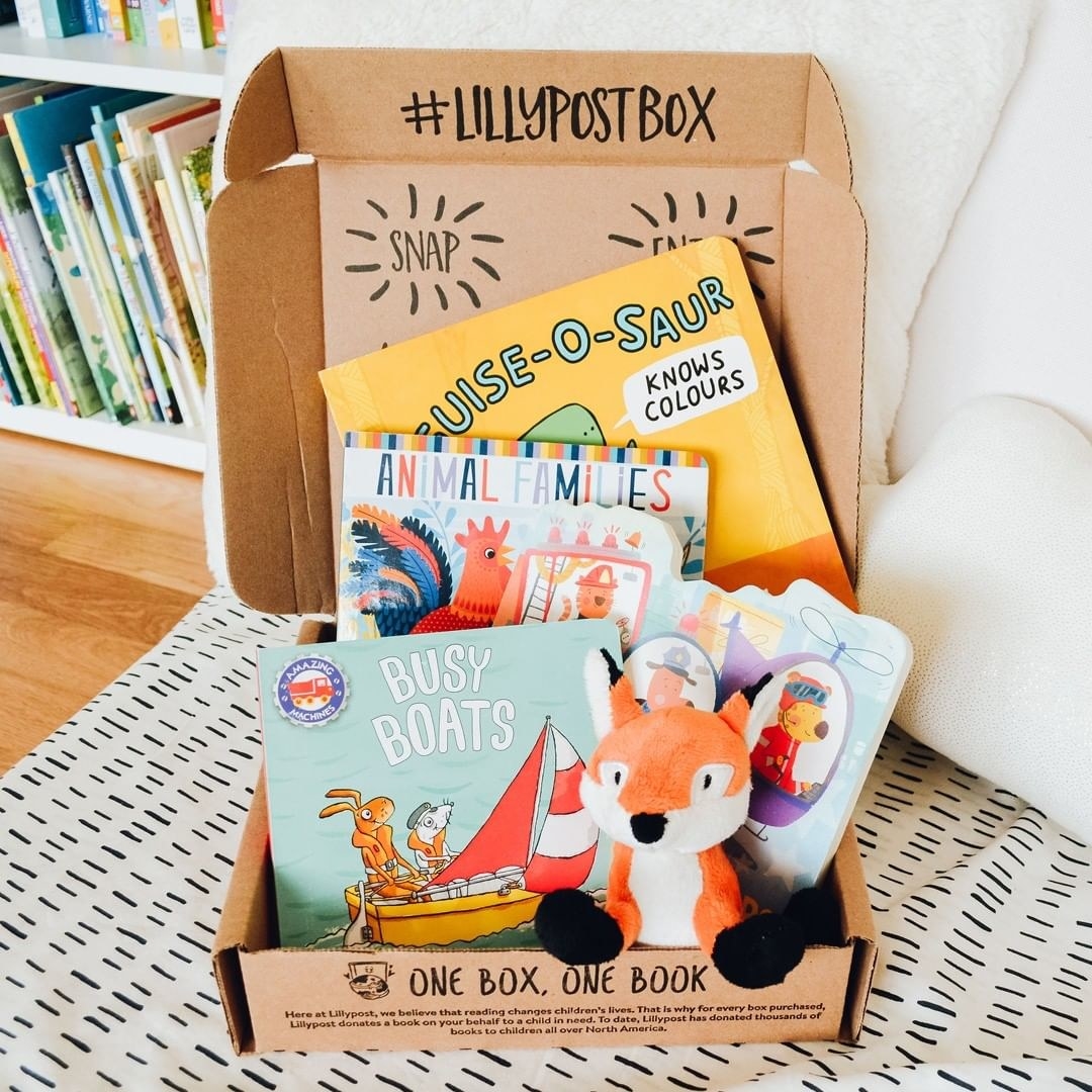 A box filled with baby books and a stuffed animal