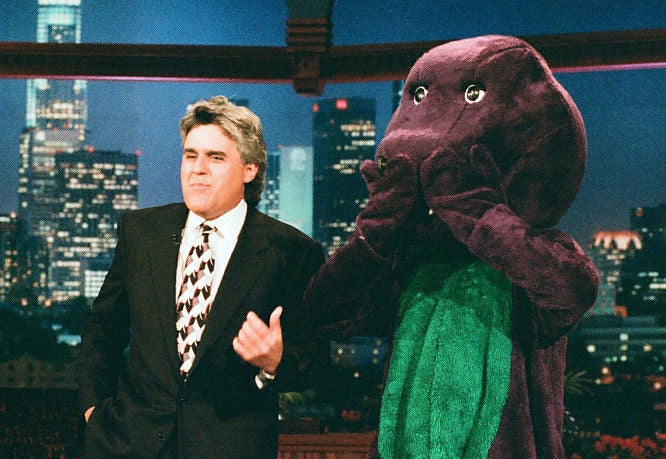 Jay doing his monologue standing next to a man in a Barney costume