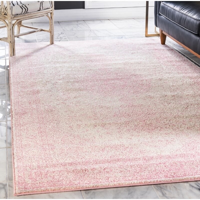 A pale pink and cream oriental patterned rectangular rug 