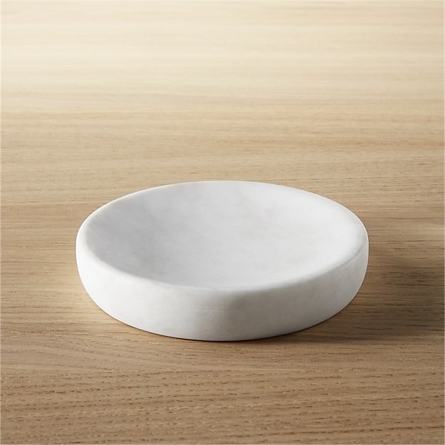 a rounded white marble soap dish