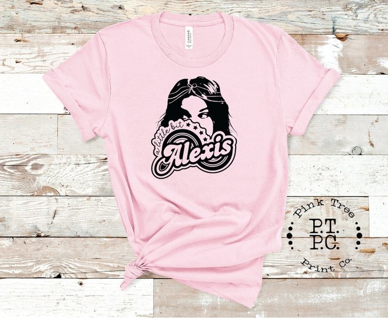 The pink tee with Alexis&#x27;s face and the text &quot;A little bit Alexis&quot;