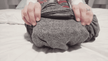 A gif of an adult putting on the blanket like a sleeping bag and scrunching up tight with it around them 