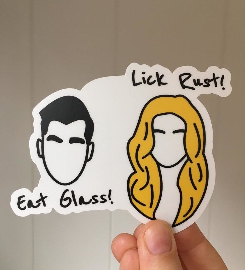 The sticker, with a silhouette of David&#x27;s face and the words &quot;Eat glass!&quot; and a silhouette of Alexis&#x27;s face and the words &quot;Lick rust!&quot;