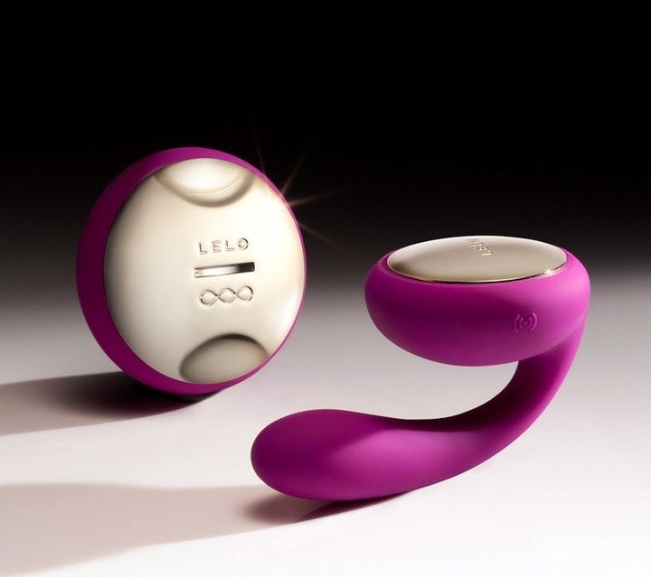 A small silicone vibe with a flattened top and a matching circular remote 
