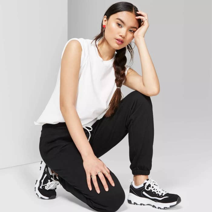 model wears black sweatpants with elastic bands around ankle 