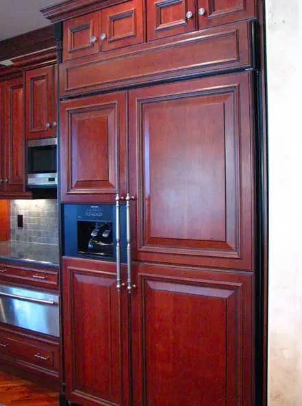 A dark cherry wood paneled fridge