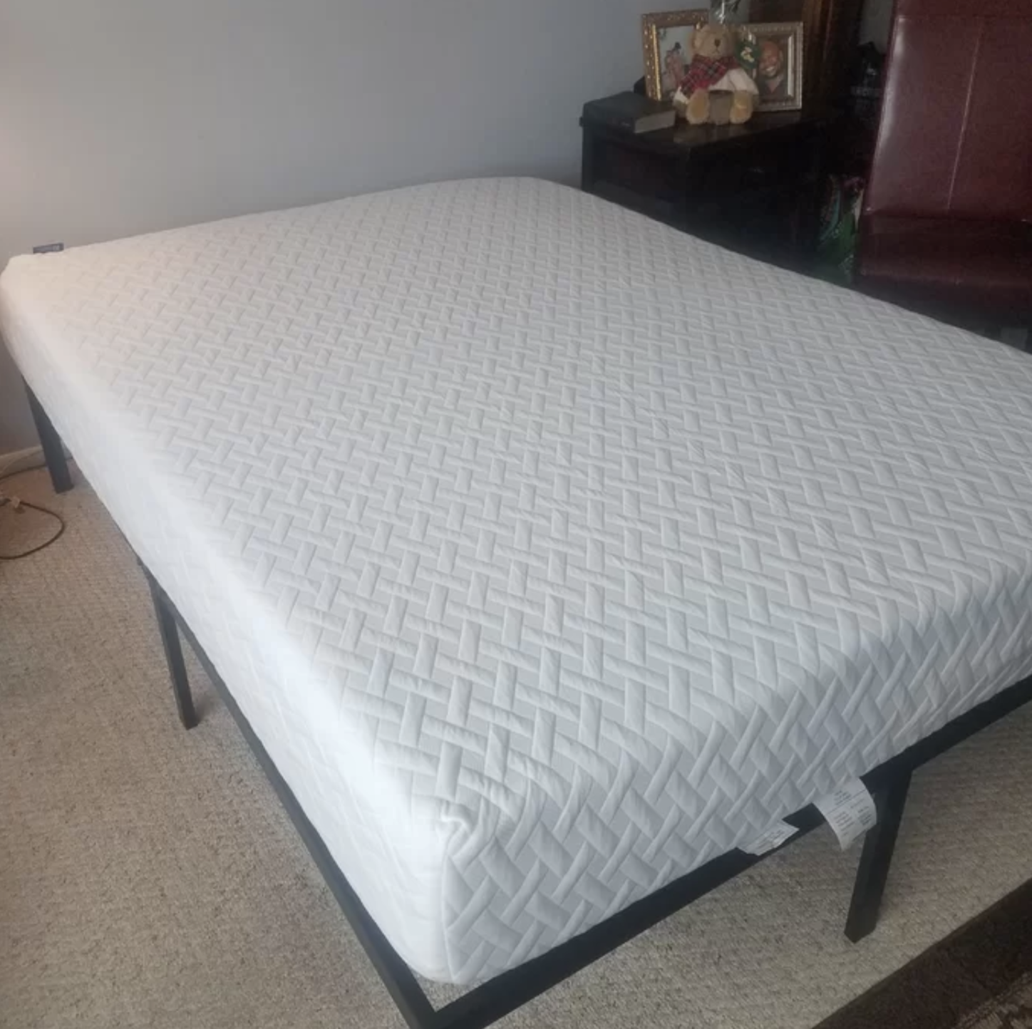 Reviewer photo of mattress covered in a mattress topper on a bed frame