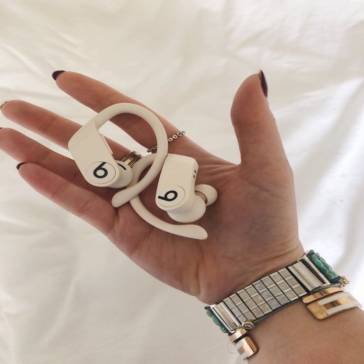 buzzfeed editor holding the white ear buds in her hand