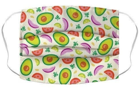 A face mask with cartoon avocados, tomatoes, onions, and limes