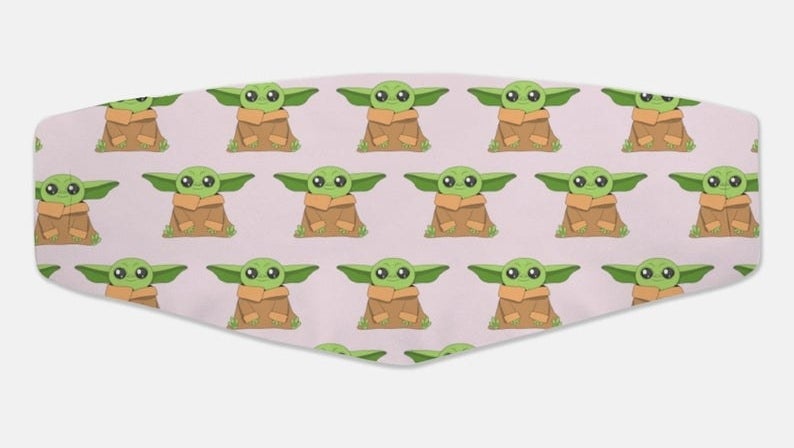 A face mask with cartoon Baby Yodas on it