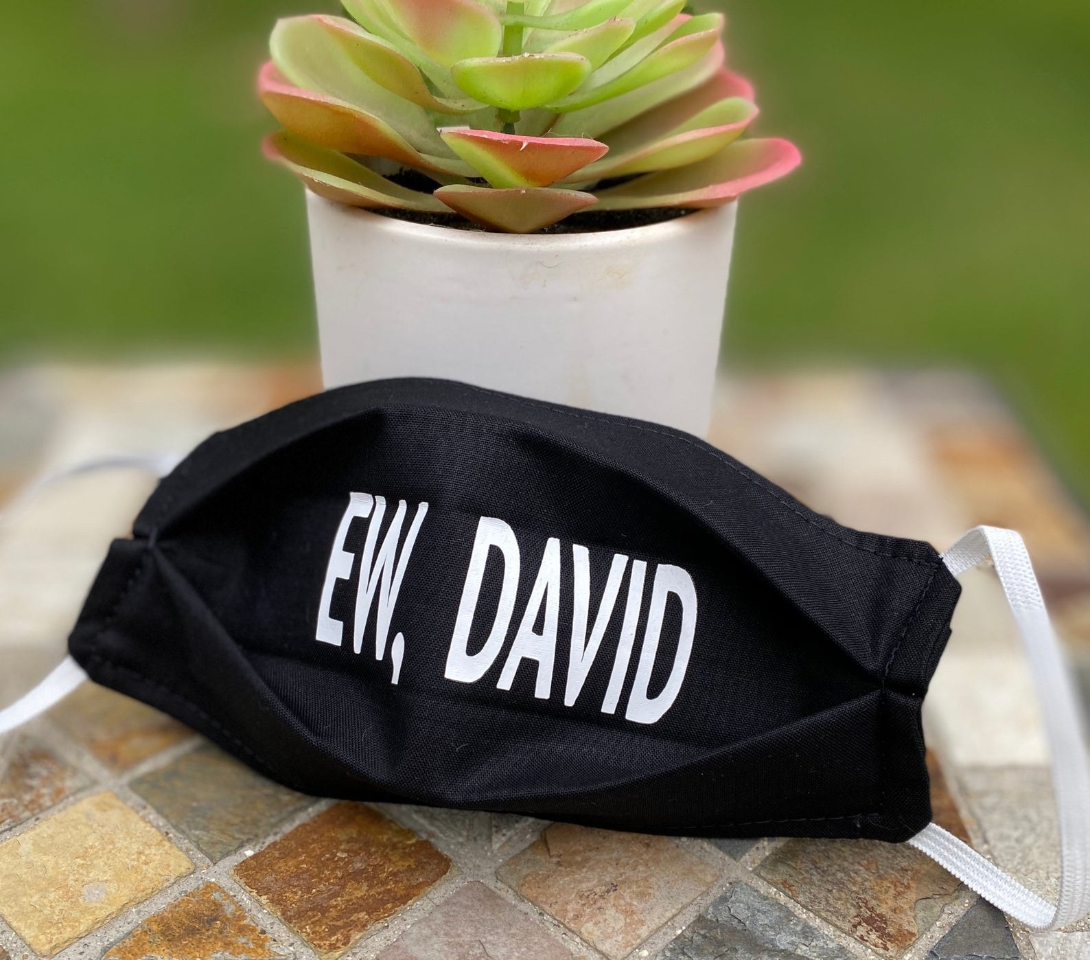 A black face mask that says &quot;ew, david&quot; in white 