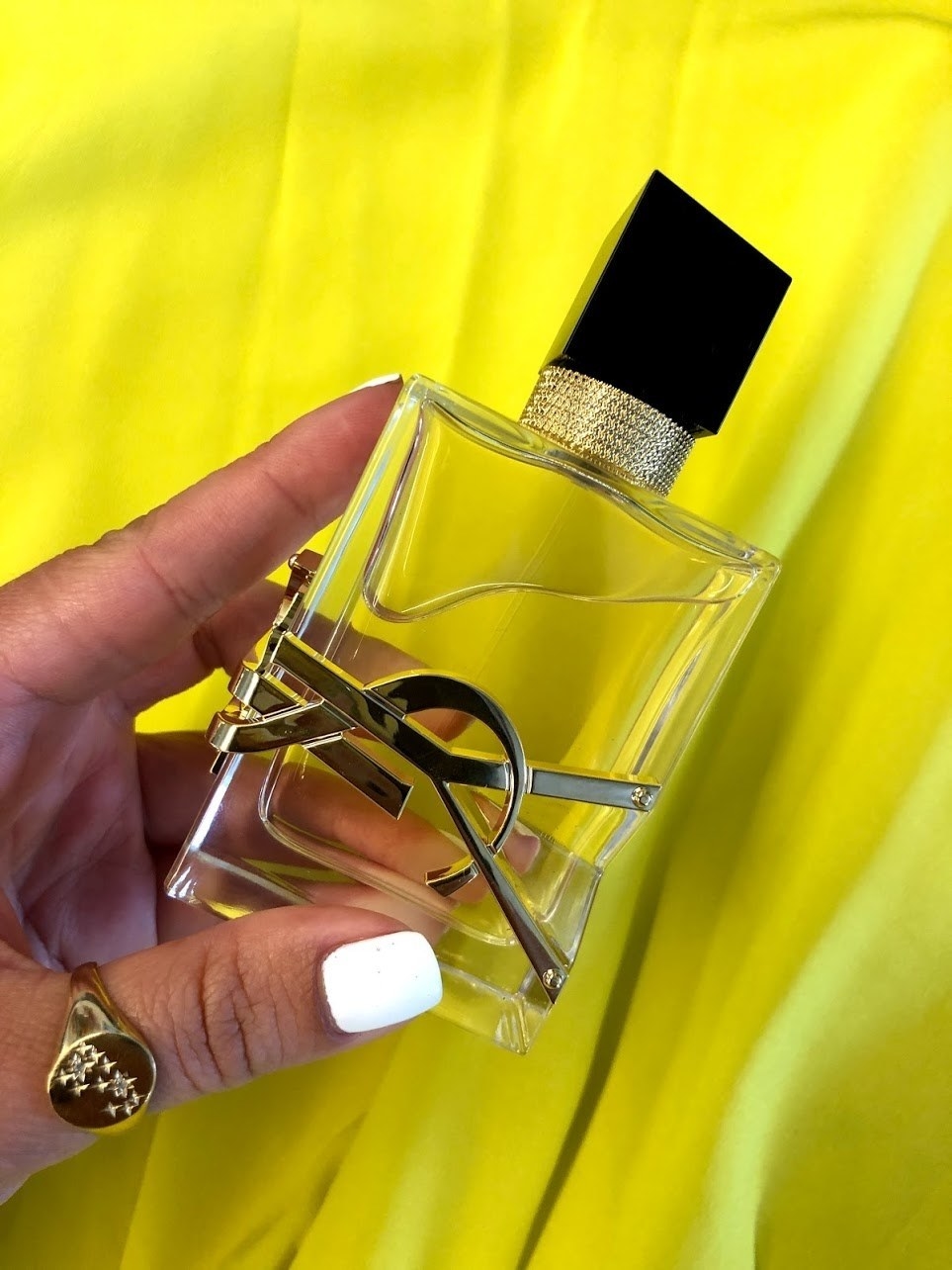 clear bottle with gold YSL logo and black cap