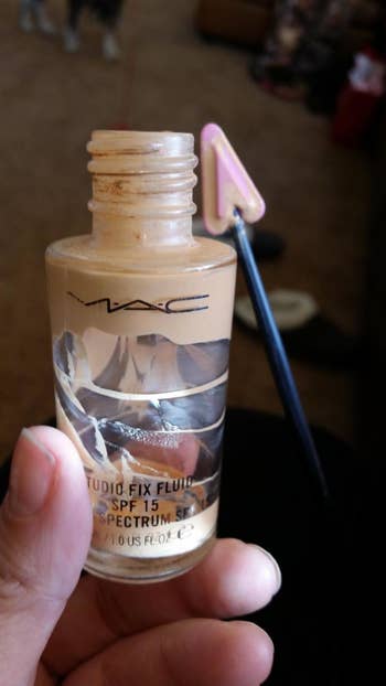 an almost empty bottle of makeup with some makeup still inside