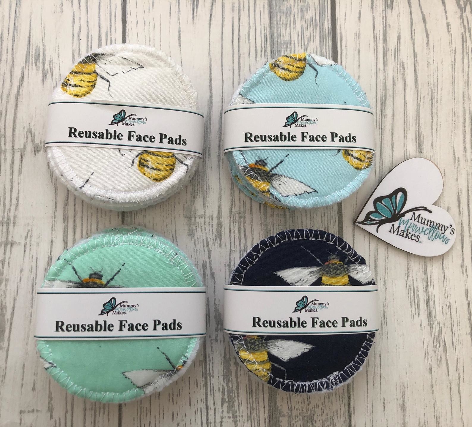 four-packs of resuable face pads in white, blue, black, and teal fabric with bees on them
