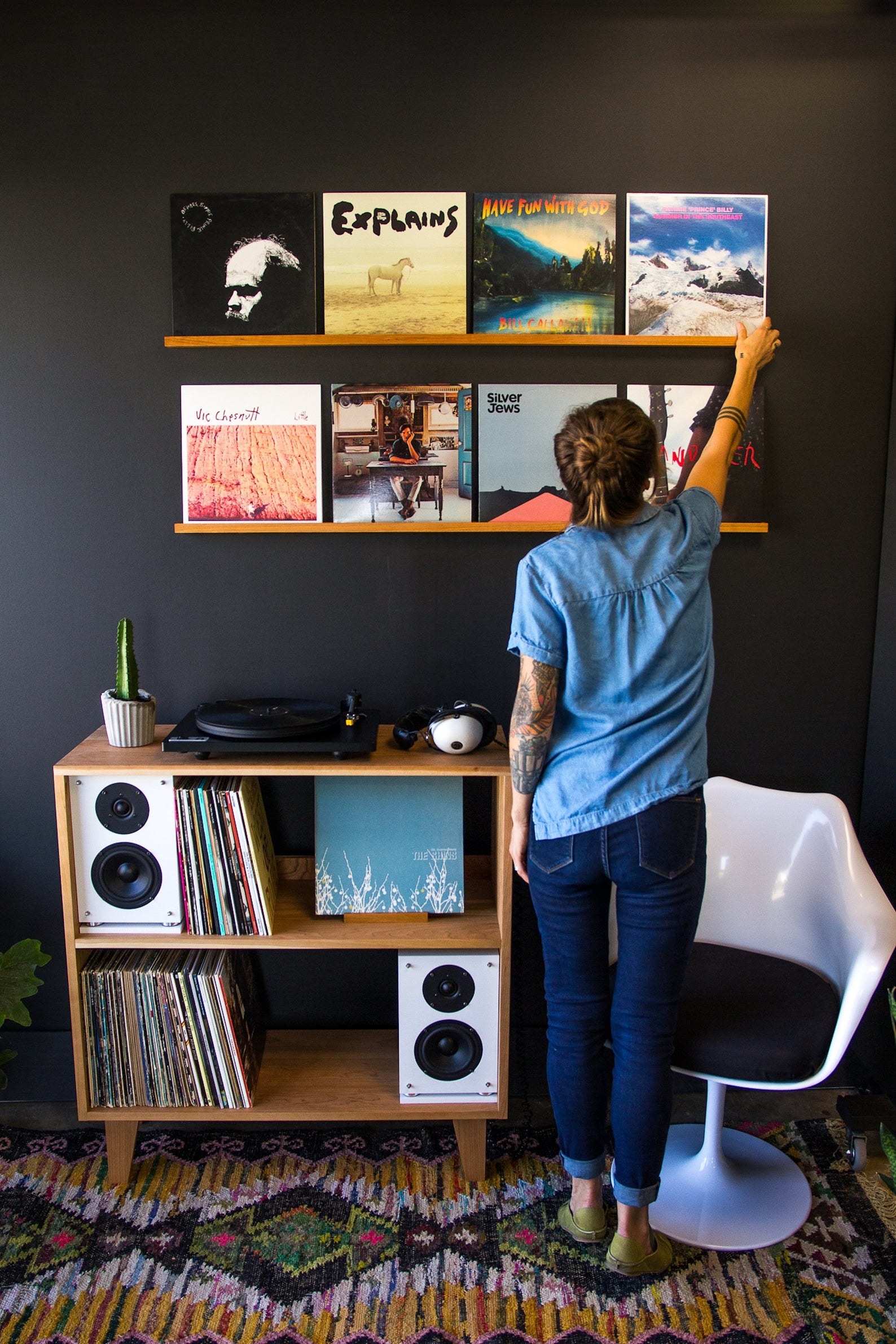 Two ledges displaying a variety of records above a record player