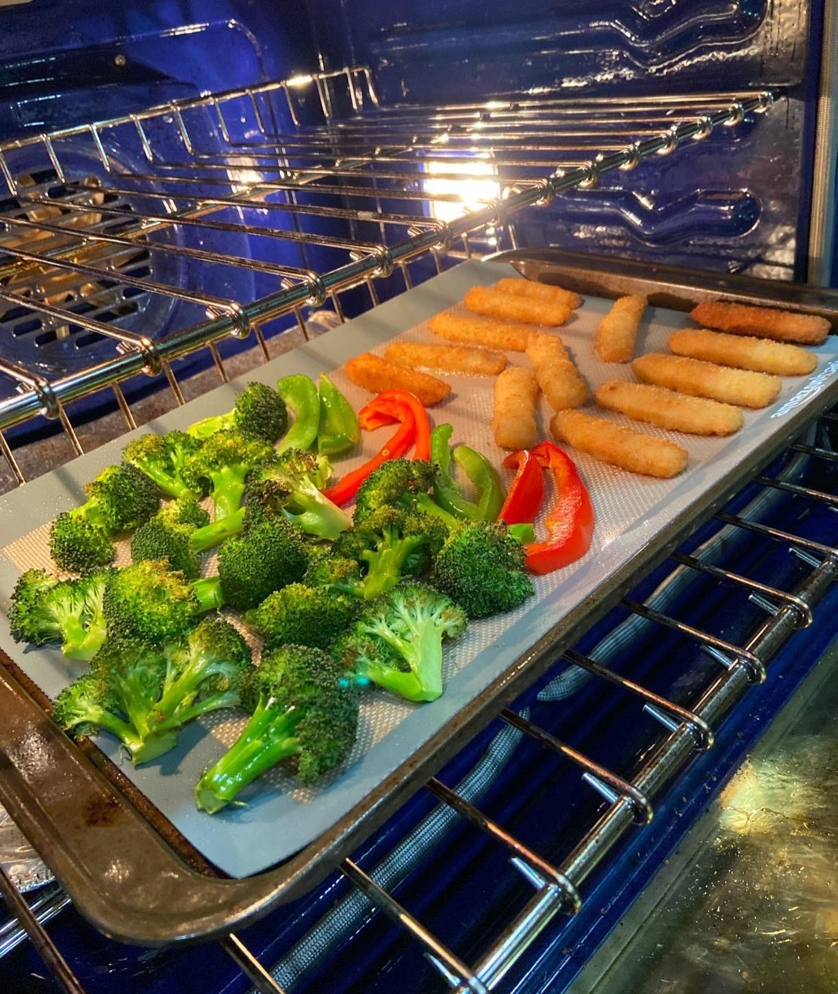 A reviewer's vegetable and mozzarella sticks cooking on a sheet pan