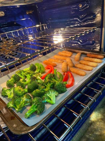 A reviewer's vegetable and mozzarella sticks cooking on a sheet pan
